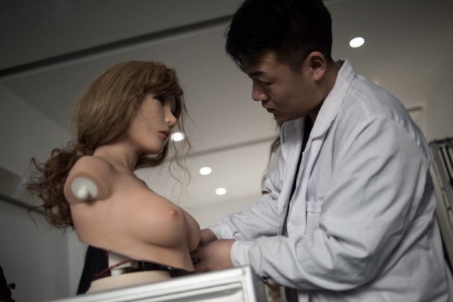 This photo taken on February 1, 2018 shows an engineer making some electronic corrections to a robot at a lab of a doll factory of EXDOLL, a firm based in the northeastern Chinese port city of Dalian. With China facing a massive gender gap and a greying population, a company wants to hook up lonely men and retirees with a new kind of companion: "Smart" sex dolls that can talk, play music and turn on dishwashers. / AFP PHOTO / FRED DUFOUR / TO GO WITH China-sex-lifestyle, FOCUS by Joanna CHIU