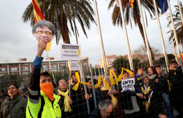 Un hombre levanta una máscara de Puigdemont durante una protesta frente al Consulado de Alemania después de que el ex presidente Carles Puigdemont fuera detenido en Alemania, durante una manifestación organizada por asociaciones independentistas en Barcelona, España, el 25 de marzo de 2018. REUTERS / Albert Gea