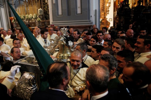 Spanish actor Antonio Banderas smiles inside a church before taking part as a penitent in the "Lagrimas and Favores" brotherhood, during a Palm Sunday procession in Malaga, Spain March 25, 2018. REUTERS/Jon Nazca