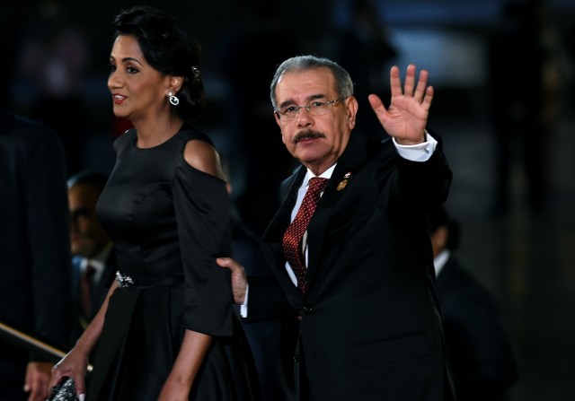 Dominican Republic's President Danilo Medina (R) waves next to his wife Candida Montilla, upon arrival at the National Theatre in Lima to attend the Eighth Summit of the Americas inauguration ceremony, on April 13, 2018. / AFP PHOTO / CRIS BOURONCLE