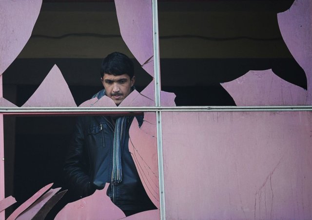 Un residente afgano mira por una ventana rota en el lugar de un ataque suicida en Kabul, el 26 de enero de 2014. SHAH MARAI AFP