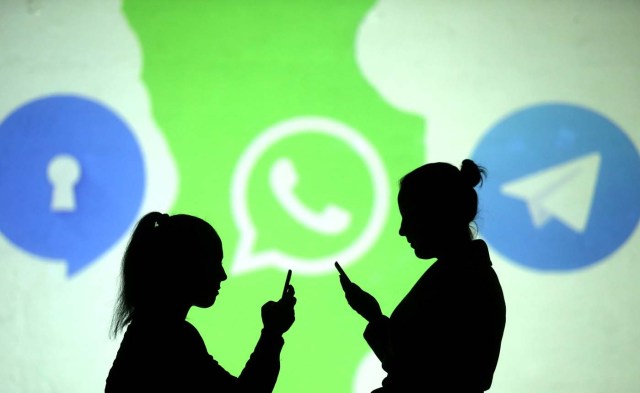 REFILE - CLARIFYING CAPTION Silhouettes of mobile users are seen next to logos of social media apps Signal, Whatsapp and Telegram projected on a screen in this picture illustration taken March 28, 2018.  REUTERS/Dado Ruvic/Illustration
