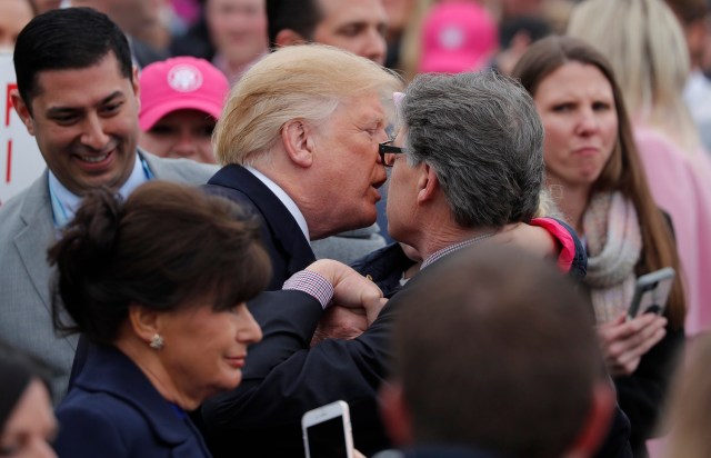 U.S. President Donald Trump kisses a little girl being held by U.S. Energy Secretary Rick Perry during the annual White House Easter Egg Roll on the South Lawn of the White House in Washington, U.S., April 2, 2018. REUTERS/Carlos Barria