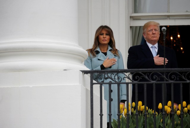 U.S. President Donald Trump and first lady Melania Trump listen to the national anthem during the annual White House Easter Egg Roll on the South Lawn of the White House in Washington, April 2, 2018. REUTERS/Leah Millis