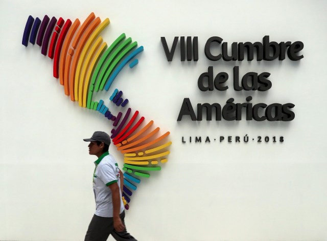 Un hombre camina junto a un logo de la Cumbre de las Américas en el centro de convenciones que albergó el encuentro en Lima. 14 de abril 2018. REUTERS/Marcos Brindicci