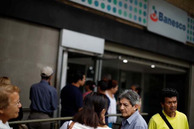 People queue to use the automated teller machines (ATM) at a Banesco bank branch in Caracas, Venezuela May 4, 2018. REUTERS/Carlos Garcia Rawlins
