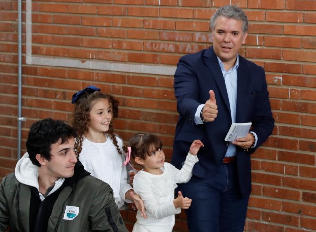 El candidato presidencial derechista Ivan Duque, acompañado por sus hijos, se prepara para emitir su voto en un colegio electoral, durante las elecciones presidenciales en Bogotá, Colombia el 27 de mayo de 2018. REUTERS / Nacho Doce