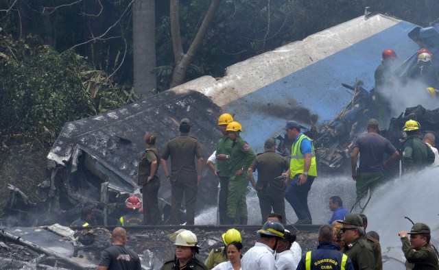 Emergency personnel work at the site of the accident after a Cubana de Aviacion aircraft crashed after taking off from Havana's Jose Marti airport on May 18, 2018. A Cuban state airways passenger plane with 113 people on board crashed on shortly after taking off from Havana's airport, state media reported. The Boeing 737 operated by Cubana de Aviacion crashed "near the international airport," state agency Prensa Latina reported. Airport sources said the jetliner was heading from the capital to the eastern city of Holguin.  / AFP PHOTO / Adalberto ROQUE