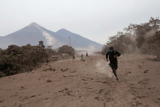 Un oficial de policía huye luego de que el volcán Fuego arrojara un nuevo flujo piroclástico en la comunidad de San Miguel Los Lotes en Escuintla, Guatemala, el 4 de junio de 2018. REUTERS / Luis Echeverría