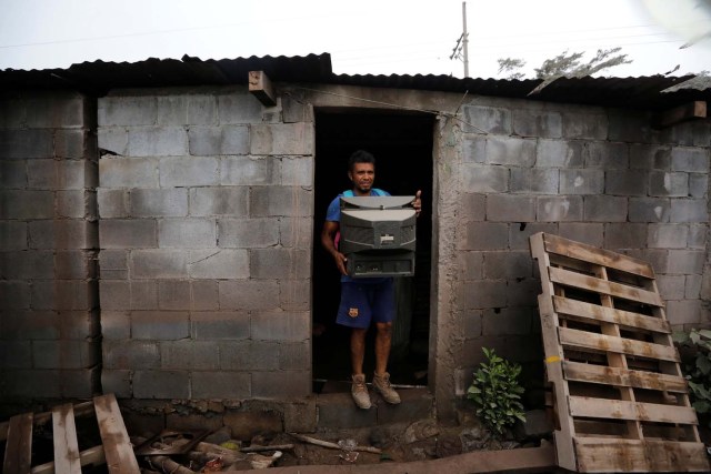 Un residente recupera un televisor de su casa en un área afectada por la erupción del volcán Fuego en la comunidad de San Miguel Los Lotes en Escuintla, Guatemala, el 4 de junio de 2018. REUTERS / Luis Echeverría