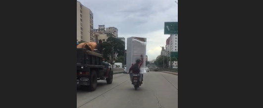 ¡INSÓLITO! Traslada UNA NEVERA en moto por plena avenida Libertador (Video)