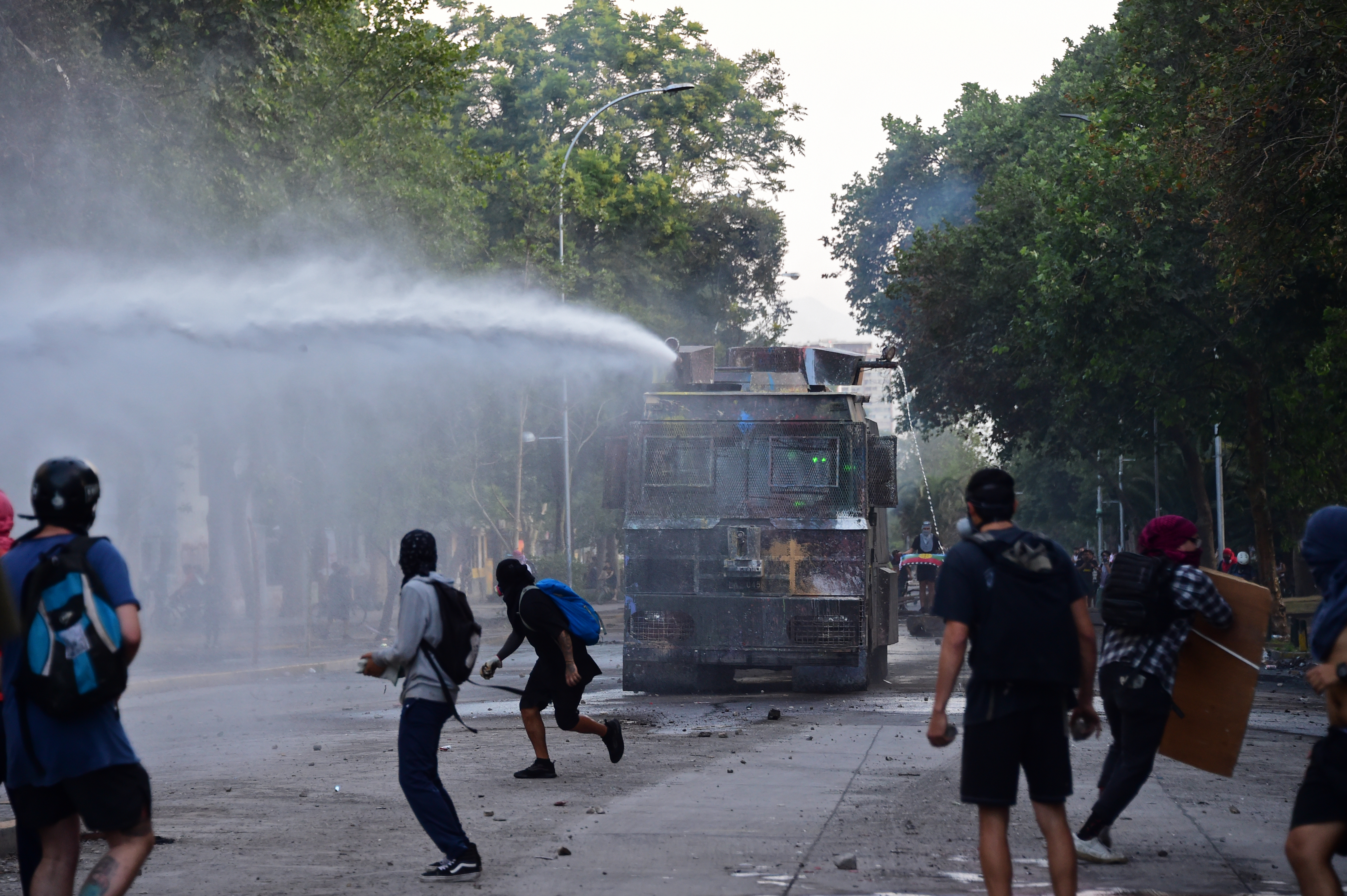 Así se vive el caos desde adentro: Manifestantes tratan de voltear a un camión de carabineros en Chile (Videos)