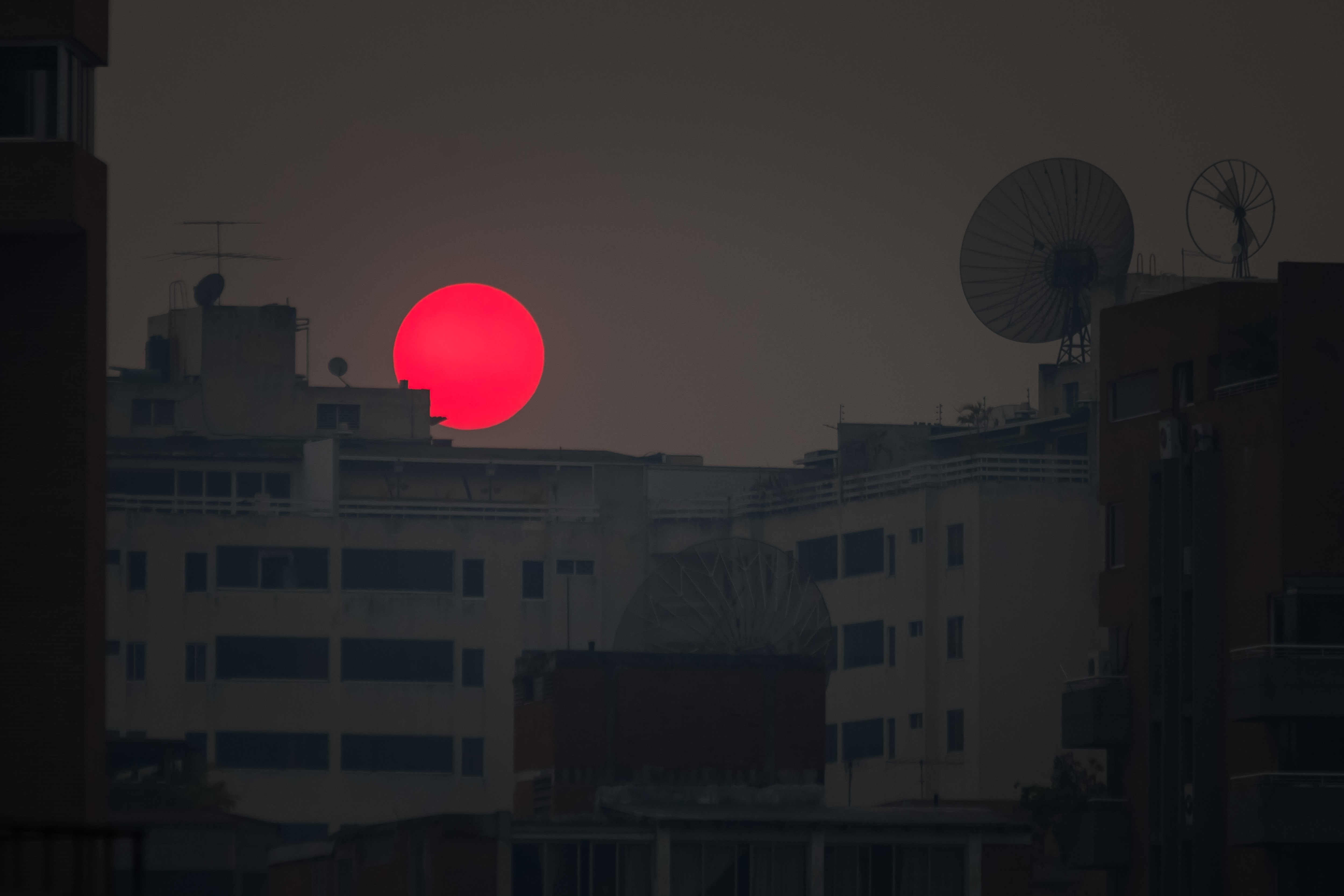 LA FOTO: Sol “rojo” se oculta entre la calima y los bloques caraqueños